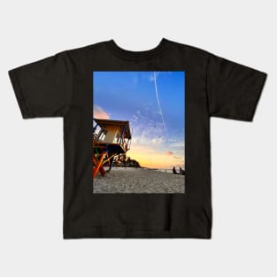 A sun-drenched beach with a crystal-clear ocean stretching out to the horizon. Kids T-Shirt